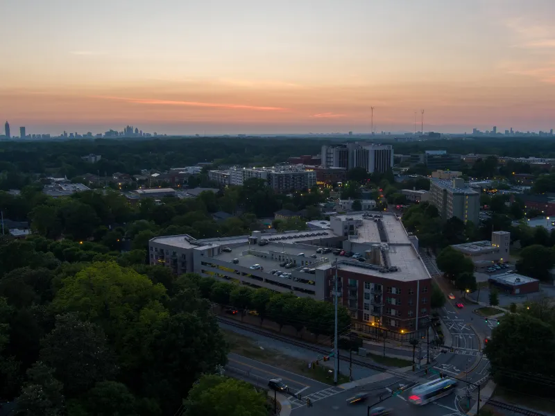 City skyline at sunset over a tree-lined neighborhood.