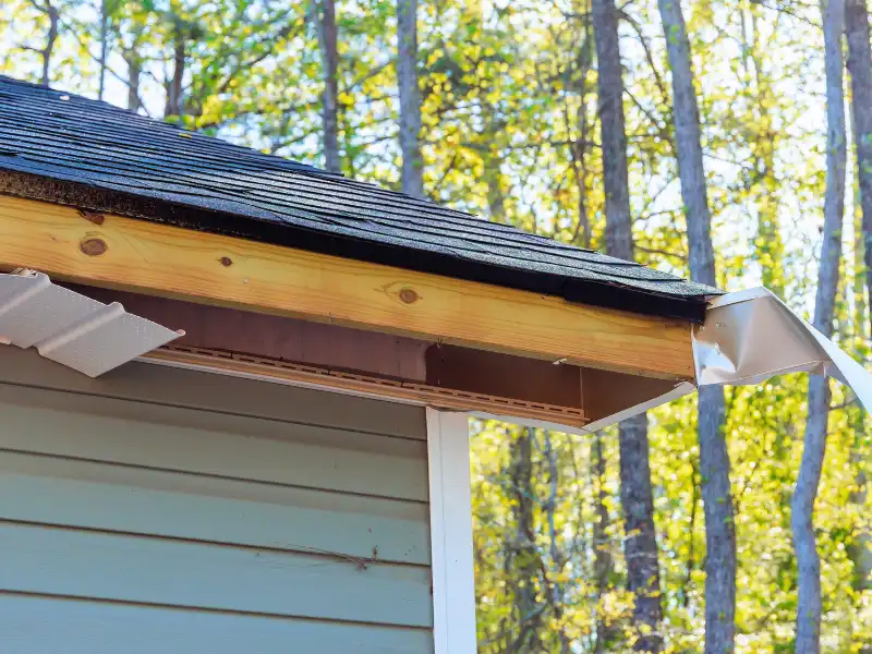 Damaged roof eave with bent flashing on a house.